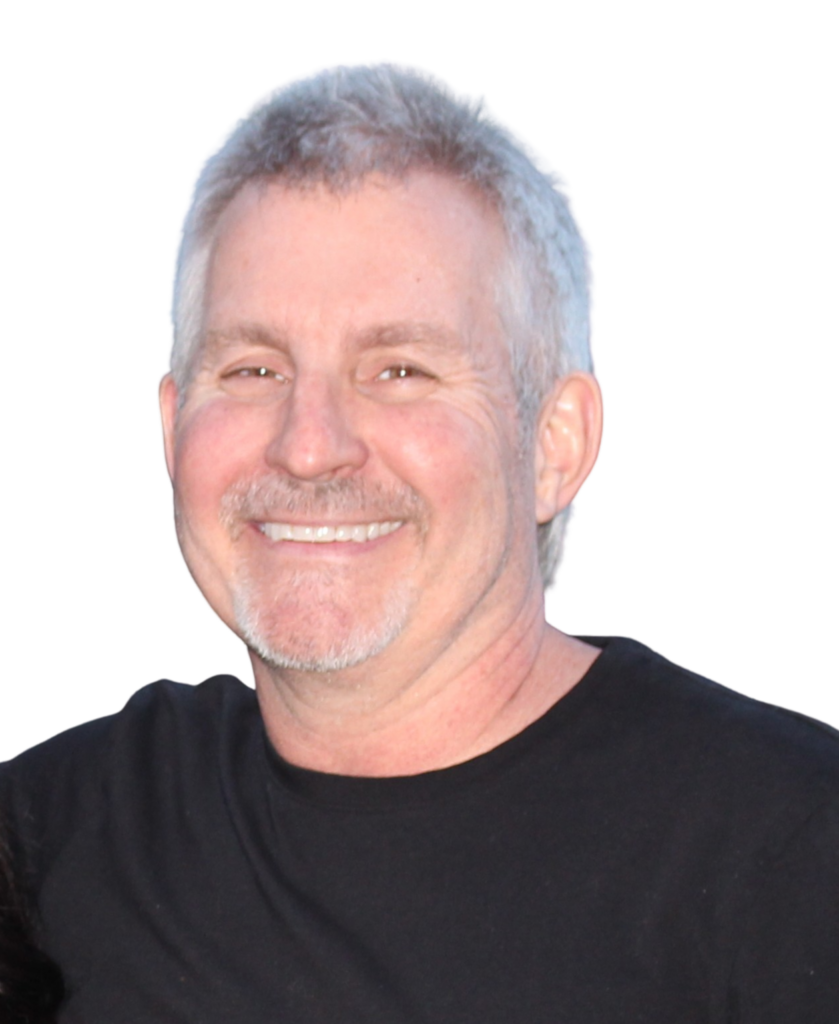 Smiling man with short gray hair and stubble, wearing a black t-shirt, against a black background