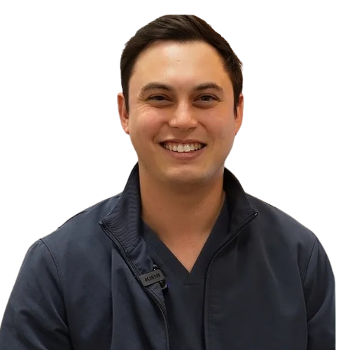 Portrait of a smiling man in a dark zip-up jacket, facing the camera against a white background.